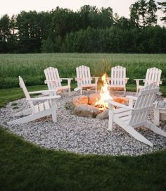 an outdoor fire pit with chairs around it