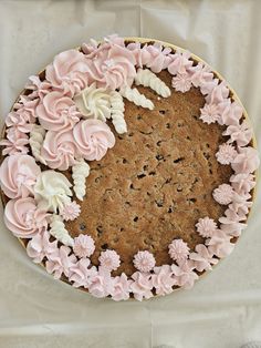 a cake decorated with flowers and icing on top of a white tableclothed surface