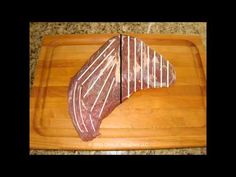 a piece of meat sitting on top of a wooden cutting board