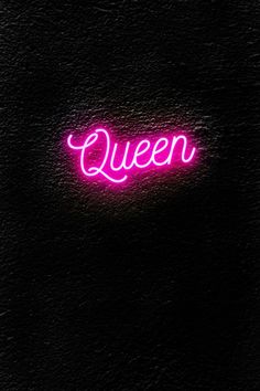 a neon sign that says queen on the side of a black wall with dark background