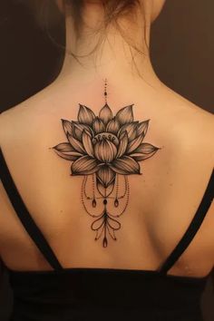 a woman's back with a lotus tattoo on it