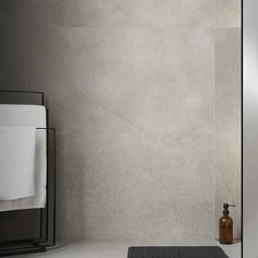 a bathroom with a sink, mirror and towel rack on the wall next to it