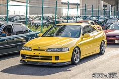 a yellow car parked next to other cars