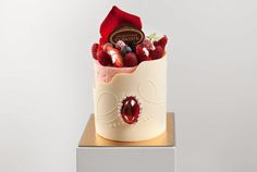 there is a cake with berries and chocolates in it on top of a stand