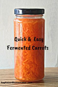 a jar filled with carrots sitting on top of a wooden table