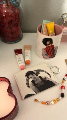 various items are displayed on a table with a heart shaped container in the middle and an image of a woman's face next to it