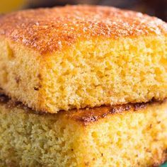 two pieces of cornbread sitting on top of a blue and green plate with bananas in the background