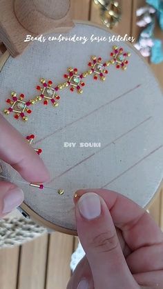 someone is working on some beading with their fingers and thumbnails in front of the needle