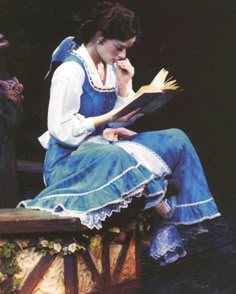 a woman sitting on a bench reading a book