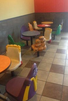 the inside of a restaurant with colorful chairs and table decorations on the floor, including donuts