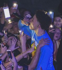 a group of people holding cell phones and taking pictures with their smartphones in front of them