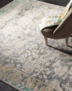 a chair sitting on top of a wooden floor next to a rug with an ornate design