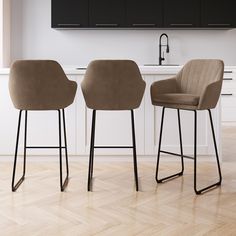 two brown chairs sitting next to each other on top of a hard wood floor