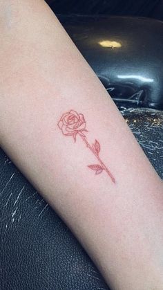 a small rose tattoo on the arm