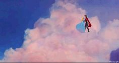 a man flying through the air on top of a blue and pink cloud filled sky