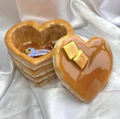 two heart shaped cookies sitting next to each other on top of a white table cloth