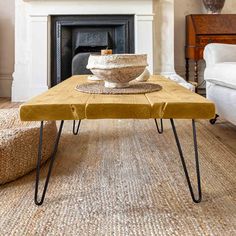 a coffee table with a bowl on it in front of a fireplace