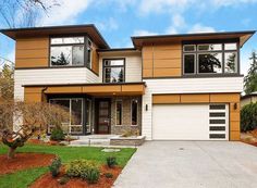 a two story house with lots of windows on the front and side of it's garage