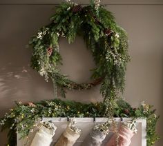 christmas stockings hanging on a mantle with greenery