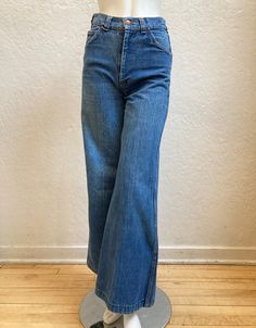 "A fantastic and classic pair of \"H.A.S.H.\" jeans! - 1970's - \"H.A.S.H.\" label - Made in California tag - Heavy weight cotton denim blue jeans - Red and yellow stitching - Medium wash - Bell bottoms / Wide legs - Two front pockets - One front coin pocket - Two back pockets - Metal zipper and button - Metal buckle on the back with \"H.A.S.H. Jeans\" star logo * Mannequin's Measurements: Waist: 24 ½\", Hips: 34 ½\" (jeans are not clipped on mannequin) ** These jeans were tight slightly below t 60s Jeans Outfit, 1970 Jeans, H2o Characters, Bellbottom Outfit, 60s Jeans, 1980s Jeans, 1970s Jeans, Thrift List, 60s Clothing