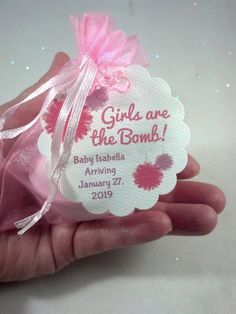 a hand holding a tag that says girl are the bomb with pink flowers on it