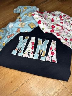 three cloths laying on top of each other with the word mmm printed on them