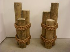 two wooden poles with rope on them are standing next to each other in front of a white wall