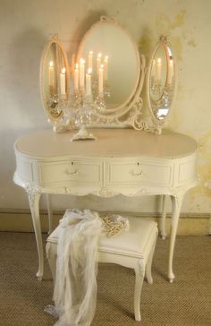 a white dressing table with candles on it