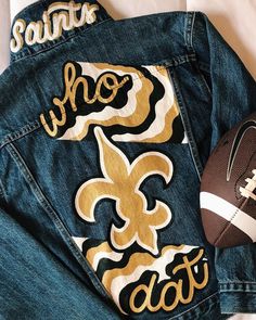 a football and jean jacket sitting on top of a bed