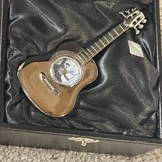 a small guitar in a black box on the floor