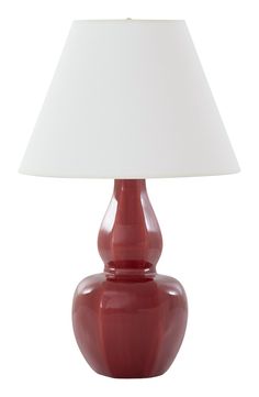 a red table lamp with a white shade on the top and bottom part of it