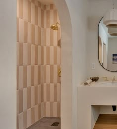 a bathroom with a sink, mirror and tiled walls