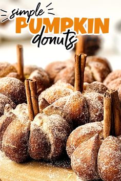 a pile of doughnuts sitting on top of a wooden table with cinnamon sticks sticking out of them