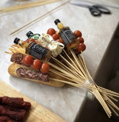 several skewers of food are arranged on top of each other, including tomatoes and olives