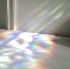 the sunlight is shining on a bed with white sheets