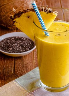 a smoothie in a glass with a blue and white striped straw sticking out of it