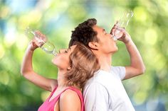 a man and woman are drinking wine from their glasses while looking up at the sky