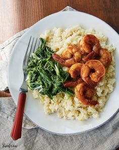 shrimp, spinach and rice on a plate with a fork