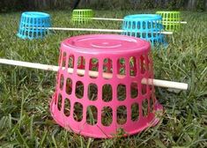 four plastic frisbees sitting in the grass near each other with sticks sticking out of them