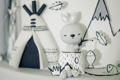 a white rabbit figurine sitting on top of a shelf next to a tent