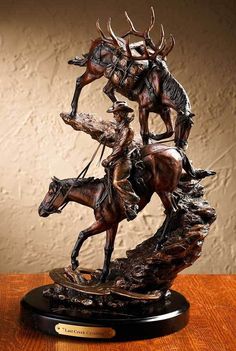 a statue of a man riding on the back of a bucking broncor