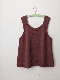 a knitted tank top hanging on a hanger