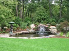 a small pond in the middle of a lush green park