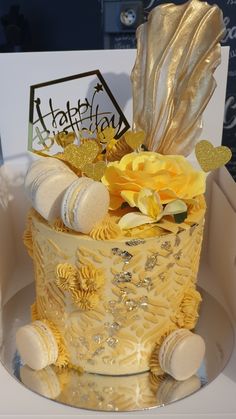 there is a yellow and white cake with flowers on it's top, sitting in a box