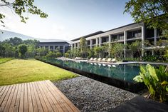 an outdoor swimming pool with lounge chairs next to it