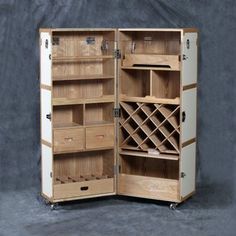 an open wooden cabinet with wine racks and drawers on wheels in front of a gray background