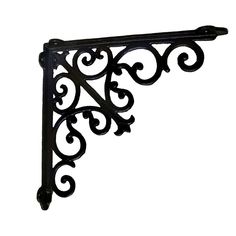 an iron shelf bracket with scrolly designs on the top and bottom, against a white background