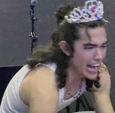 a man wearing a tiara while sitting at a table