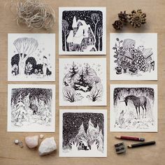 six black and white cards on a table with some rocks, pencils and pine cones