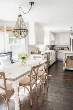 a dining room table with chairs and a chandelier hanging from it's ceiling